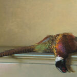 A realistic painting by a Duluth MN artist depicts a pheasant lying on its side atop a light-colored table. The vividly detailed feathers showcase green, red, and brown hues against the backdrop of a plain, soft beige wall.
