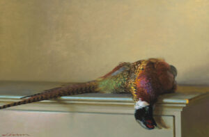 A realistic painting by a Duluth MN artist depicts a pheasant lying on its side atop a light-colored table. The vividly detailed feathers showcase green, red, and brown hues against the backdrop of a plain, soft beige wall.
