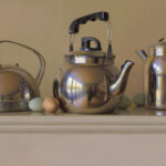 A still life by a Duluth MN artist showcases three metallic kettles on a pedestal. Scattered around the kettles are three green eggs and one brown egg, creating a reflective interplay of light and color against the smooth surfaces.