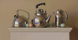 A still life by a Duluth MN artist showcases three metallic kettles on a pedestal. Scattered around the kettles are three green eggs and one brown egg, creating a reflective interplay of light and color against the smooth surfaces.
