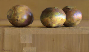 A painting by a Duluth MN artist features three round objects with metallic hues on a textured cardboard surface. The muted yellow background complements the reflective quality of the objects, while shadows and light enhance the scene's dimensionality.