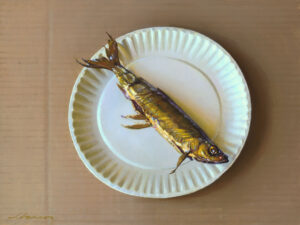 A realistic painting by a Duluth MN artist showcases a single fish on a white paper plate against a brown backdrop. The fish glows with a golden hue and detailed fins, capturing intricate realism.