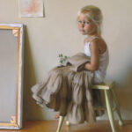 A young girl with blonde hair sits on a green stool, wearing a white top and a tan skirt. She holds fabric in her lap and looks toward the viewer. Behind her, a framed picture and a child's drawing hang, hinting at the playful creativity of a Duluth MN artist.