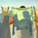 A series of colorful garments hang on a clothesline, casting shadows. The silhouette of a person, perhaps a Duluth MN artist, is visible behind one of the garments against a bright sky, giving the scene a warm and serene atmosphere.