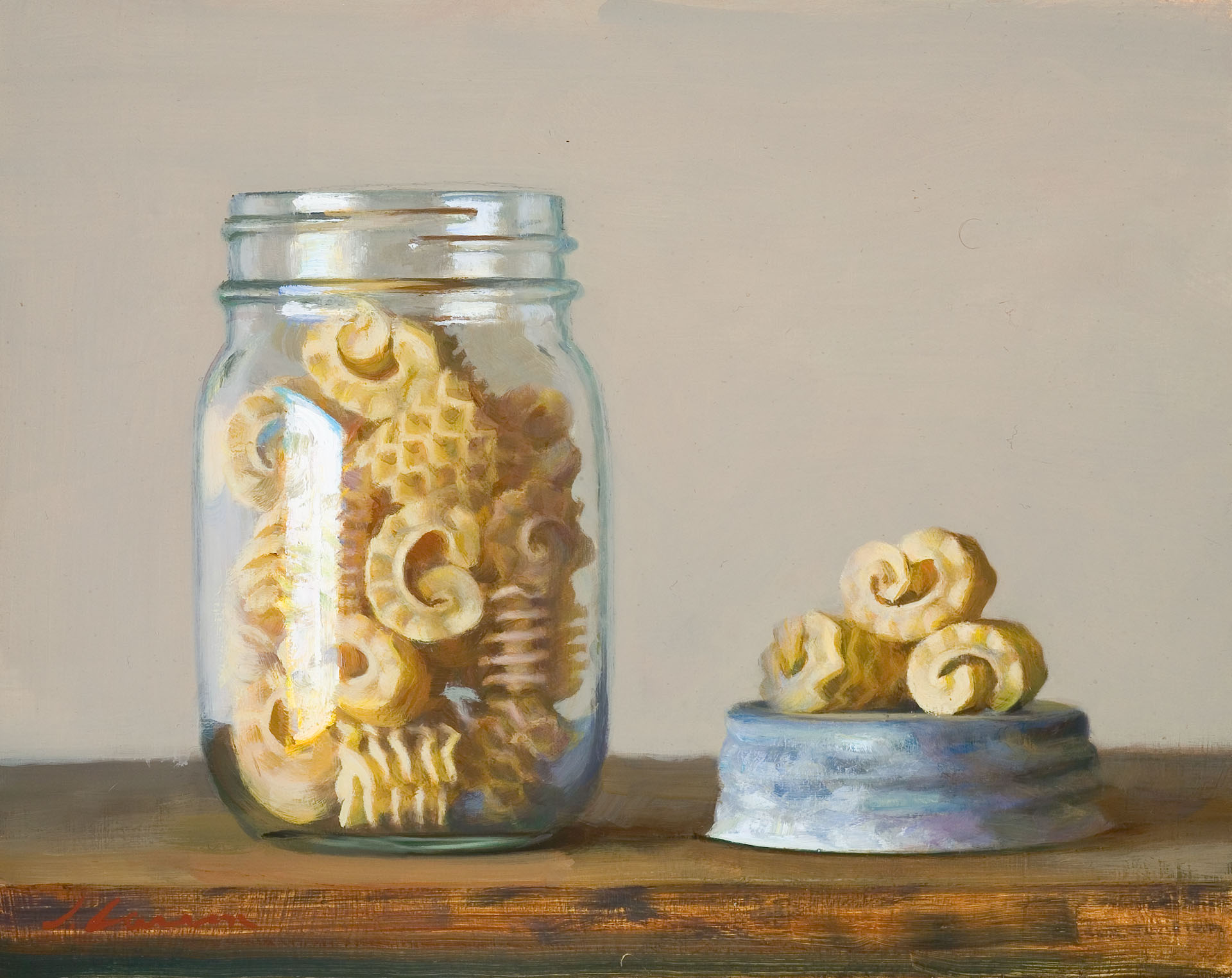 A glass jar filled with intricately shaped pasta, a creation by a talented Duluth MN artist, is placed on a wooden surface. The jar's lid lies beside it with a few pieces of pasta resting on top. The lighting casts soft shadows, creating a warm, inviting scene.