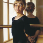 A young girl in a black ballet outfit, captured by a Duluth MN artist, stands in front of a mirror with her reflection visible. She gazes thoughtfully at the viewer, sunlight streaming through large windows in the background illuminating her contemplative expression.