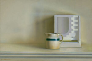 A cream-colored pitcher with a green stripe sits on a light surface next to a geometric white abstract object featuring a framed cut-out design with steps and curves, all against a soft beige background.