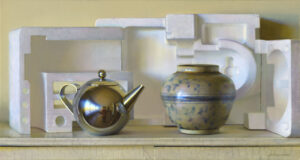 A still life composition featuring a shiny metal teapot, a ceramic vase with blue floral patterns, and geometric white foam shapes arranged on a shelf with a pale yellow background.